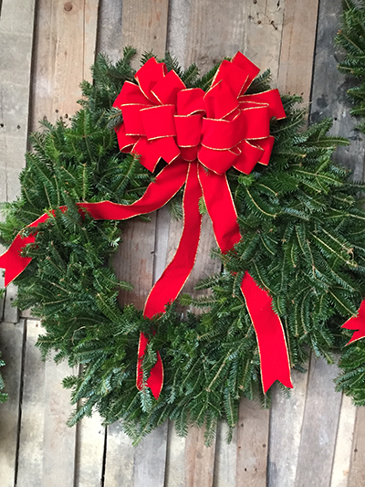 Traditional wreath with Fraser Fir with a big red bow available at Haynie's Green Acres Christmas Tree Farm gift shop.